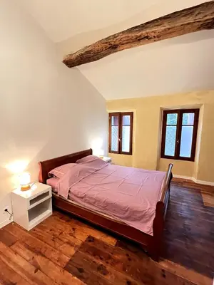 a bedroom with a bed and two windows at Maison de village pleine de charme, 7 couchages in Vingrau