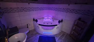 a bathroom with a tub with purple lights in it at Insinuances in Douzens