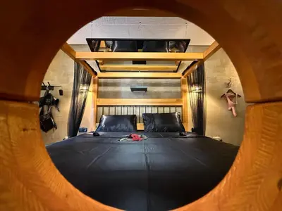 a bedroom with a large bed through a round window at Insinuances in Douzens
