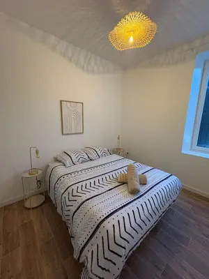 a bedroom with a bed with a striped comforter at Albert I Ground floor l Terrace l Garden l Air conditioning in Castres