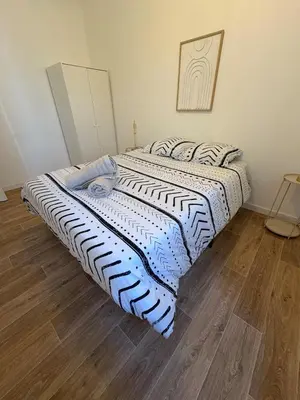 a large bed in a room with a wooden floor at Albert I Ground floor l Terrace l Garden l Air conditioning in Castres