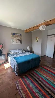a bedroom with a large bed and a rug at Le Nid de Marguerite in Castelnaudary