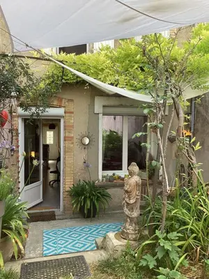 a small house with a statue in the front yard at Le Nid de Marguerite in Castelnaudary