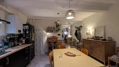 a kitchen and dining room with a table and a counter at Le Nid de Marguerite in Castelnaudary