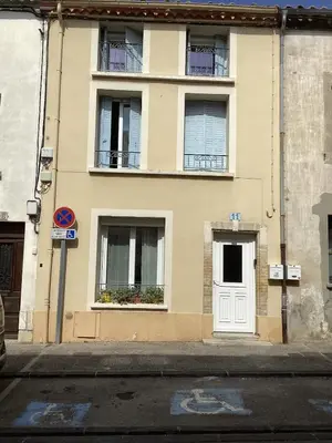a building with windows and a white door at Le Nid de Marguerite in Castelnaudary