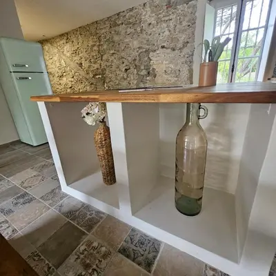 a counter with a vase and a bottle on it at Domaine VILLECARLA, Gîte 2 Canal du Midi Carcassonne in Villedubert