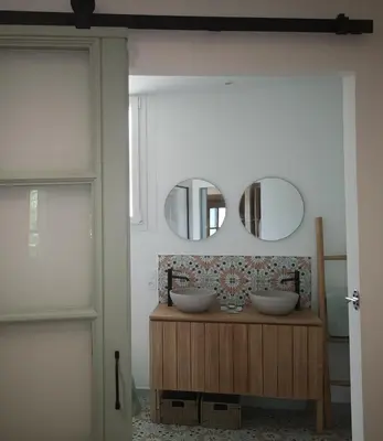 a bathroom with two sinks and two mirrors at Une chambre au jardin in Saint-Pons-de-Thomières