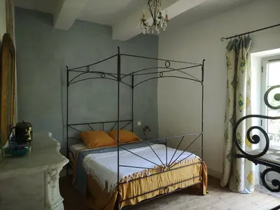 a bedroom with a bed with a metal bed frame at Une chambre au jardin in Saint-Pons-de-Thomières