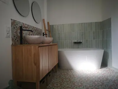 a bathroom with a tub and a sink at Une chambre au jardin in Saint-Pons-de-Thomières