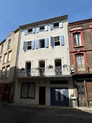 an apartment building with windows and balconies on a street at Tout Le Monde in Quillan