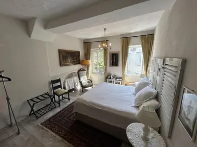 a bedroom with a large bed and a living room at Tout Le Monde in Quillan