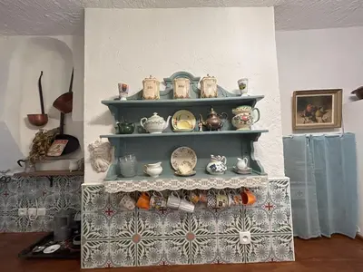 a shelf with a bunch of vases and dishes on it at Tout Le Monde in Quillan