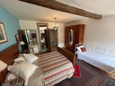 a bedroom with a bed and a chair in a room at Tout Le Monde in Quillan