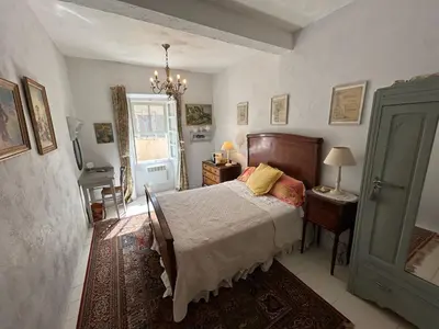 a bedroom with a bed and a table and a window at Tout Le Monde in Quillan