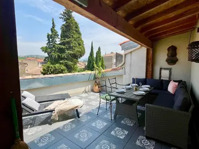 a patio with a table and chairs on a balcony at The Artist's House Limoux in Limoux