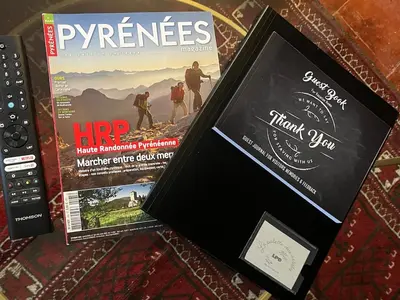 two magazines sitting on a table with a remote control at The Artist's House Limoux in Limoux