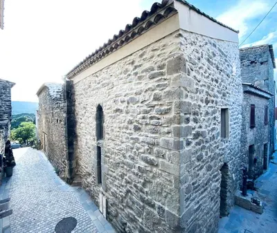 an old stone building with a stone wall at Le Bastion, 15 guests, 5 suites, 5 baths, AC in Pouzols-Minervois