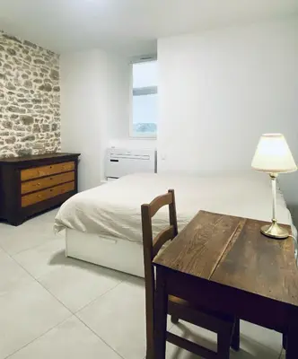 a bedroom with a bed and a table with a lamp at Le Bastion, 15 guests, 5 suites, 5 baths, AC in Pouzols-Minervois