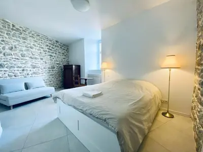 a bedroom with a bed and a brick wall at Le Bastion, 15 guests, 5 suites, 5 baths, AC in Pouzols-Minervois