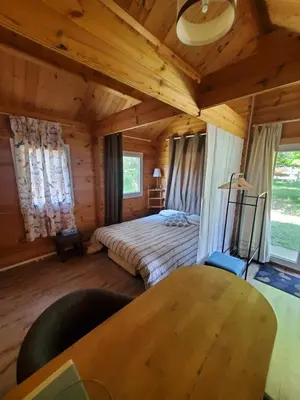 a bedroom in a log cabin with a bed and a table at Le Chalet du Grain d'Orient in Caudiès-de-Fenouillèdes