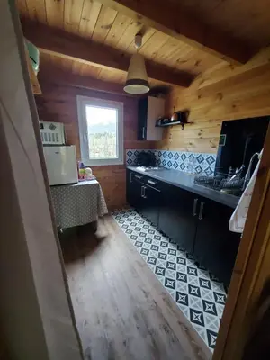 a kitchen with wooden walls and a wooden floor at Le Chalet du Grain d'Orient in Caudiès-de-Fenouillèdes