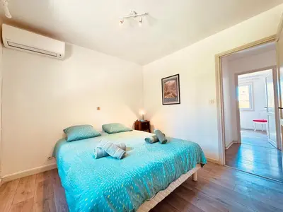 a bedroom with a large blue bed with blue pillows at Maison entière tout confort pour 7 personnes in Bize-Minervois