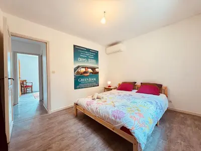 a bedroom with a bed and a sign on the wall at Maison entière tout confort pour 7 personnes in Bize-Minervois