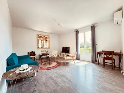 a living room with a blue couch and a table at Maison entière tout confort pour 7 personnes in Bize-Minervois