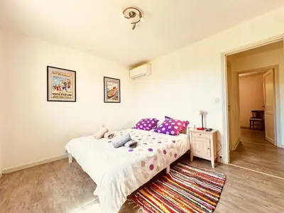 a bedroom with a bed with purple pillows at Maison entière tout confort pour 7 personnes in Bize-Minervois