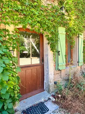 a house with a wooden door and a window at La Maison du Rond in Coustouge
