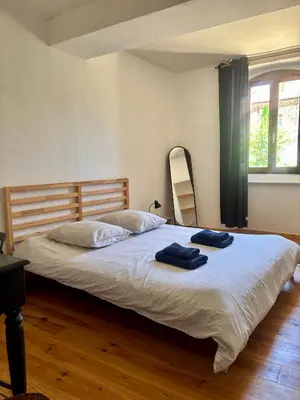a bedroom with a bed with two towels on it at La Maison du Rond in Coustouge