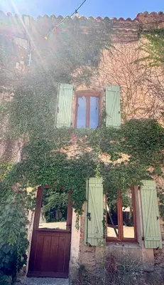 a house with green ivy growing on the side of it at La Maison du Rond in Coustouge
