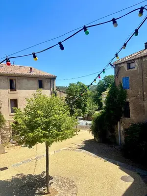 a tree in the middle of a courtyard with lights at La Maison du Rond in Coustouge