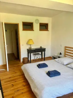 a bedroom with a bed with two blue towels on it at La Maison du Rond in Coustouge