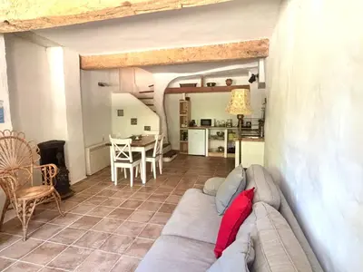 a living room with a couch and a kitchen at La Maison du Rond in Coustouge