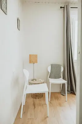 a room with two white chairs and a table and a lamp at Gîte - Holiday Home Vent Cers in Limoux