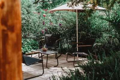 a patio with a table and chairs and an umbrella at Gîte - Holiday Home Vent Cers in Limoux