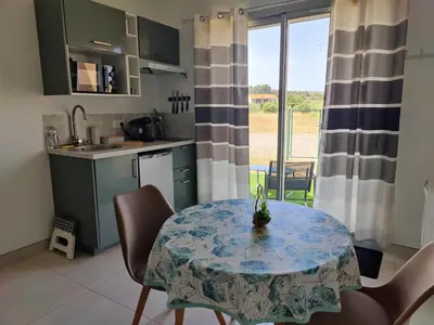 a kitchen and dining room with a table and a window at Studio cosy proche des vignes in Roubia
