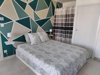 a bedroom with a bed with a geometric wall at Studio cosy proche des vignes in Roubia