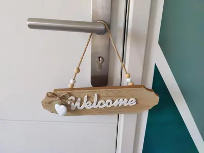 a wooden welcome sign hanging on a door at Studio cosy proche des vignes in Roubia