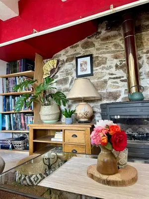 a room with a table with a vase of flowers at Maison de la Mûre, Haut-Languedoc Park in Saint-Vincent