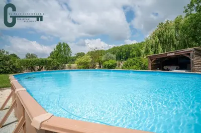 a large blue swimming pool in a yard at Séjour détente avec spa, piscine et sauna in Mas-Saintes-Puelles