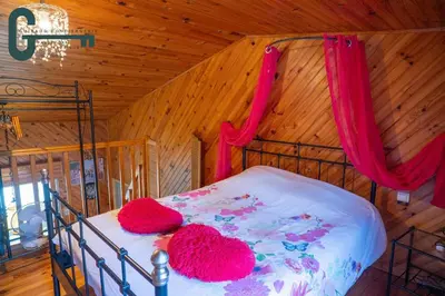 a bedroom with a bed with two red hats on it at Séjour détente avec spa, piscine et sauna in Mas-Saintes-Puelles