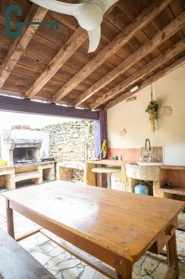 a kitchen with a wooden table in a room at Séjour détente avec spa, piscine et sauna in Mas-Saintes-Puelles