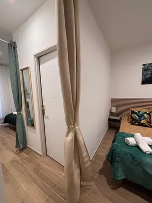 a bedroom with a large bed with a black blanket at L'Emeraude in Narbonne