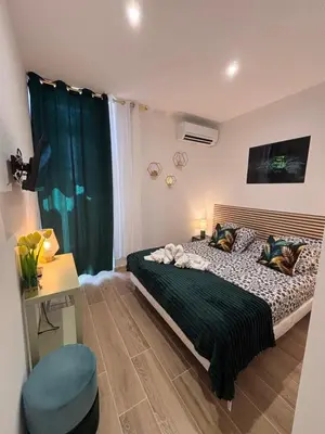 a bedroom with a bed with a desk and a television at L'Emeraude in Narbonne