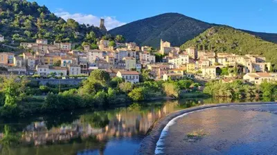 a town on a hill next to a body of water at L'Estaple in Berlou