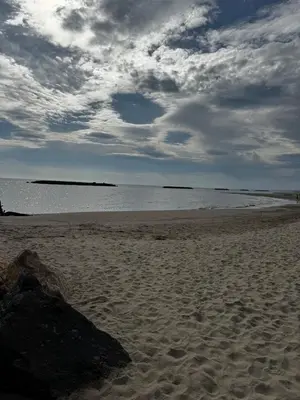 a beach with a rock in the sand and the ocean at L'Estaple in Berlou