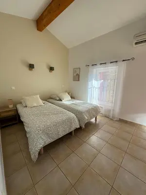 a bedroom with two beds and a window at L'Estaple in Berlou