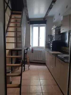 a kitchen with a spiral staircase and a window at Chez Timmy in Oupia